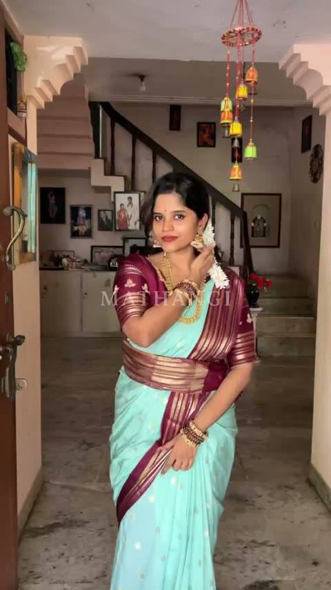 The sea green and maroon saree held open before it is draped