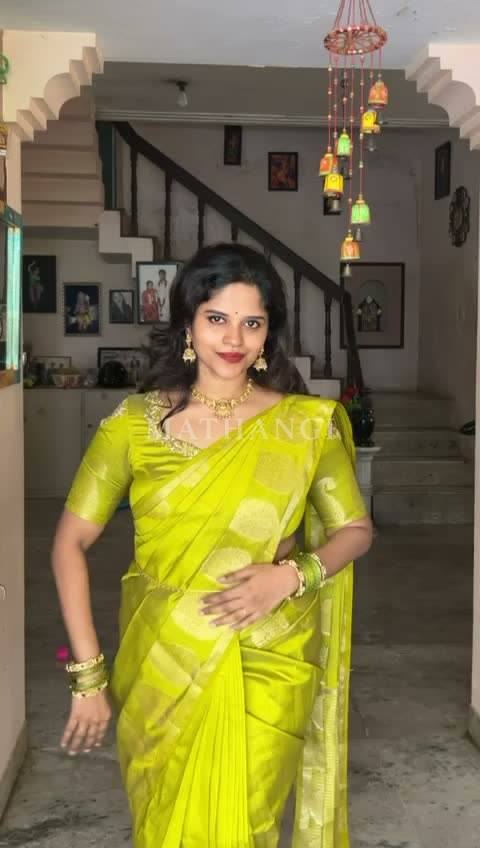 The lime and gold saree held open before it is draped