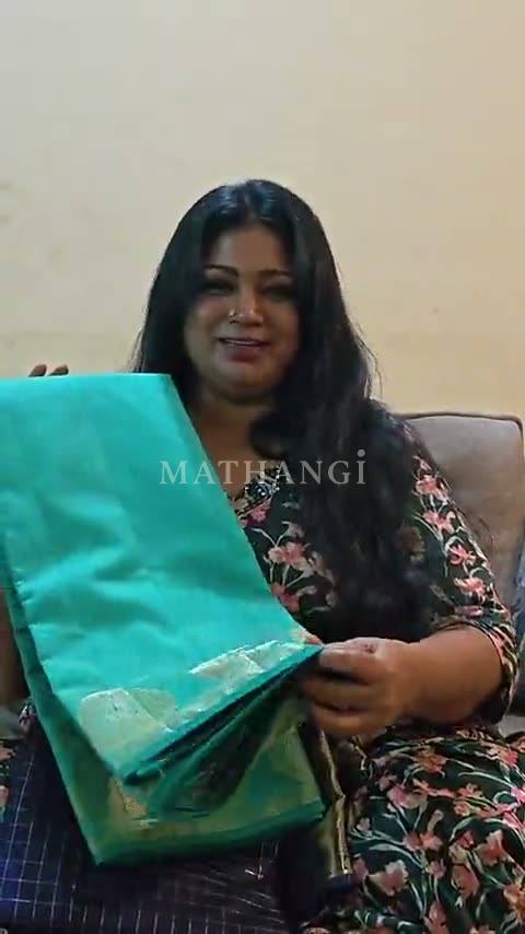 A teal saree with gold buttas and a navy saree with gold checks, unfolded one after the other